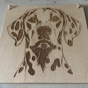 A dalmatian on a wood plaque